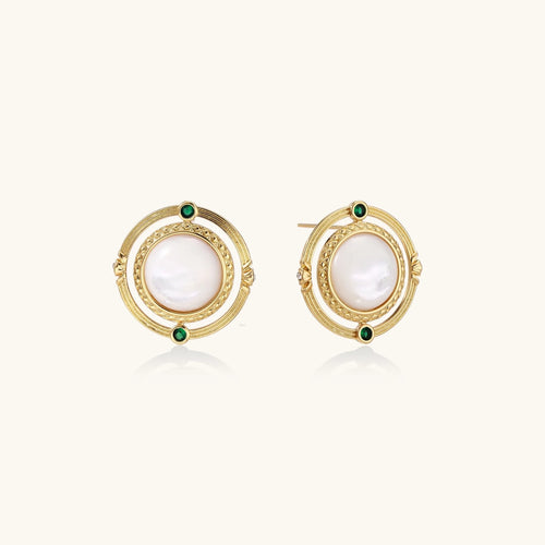 Circular gold stud earrings with iridescent mother-of-pearl center and green zirconia accents on cream background.